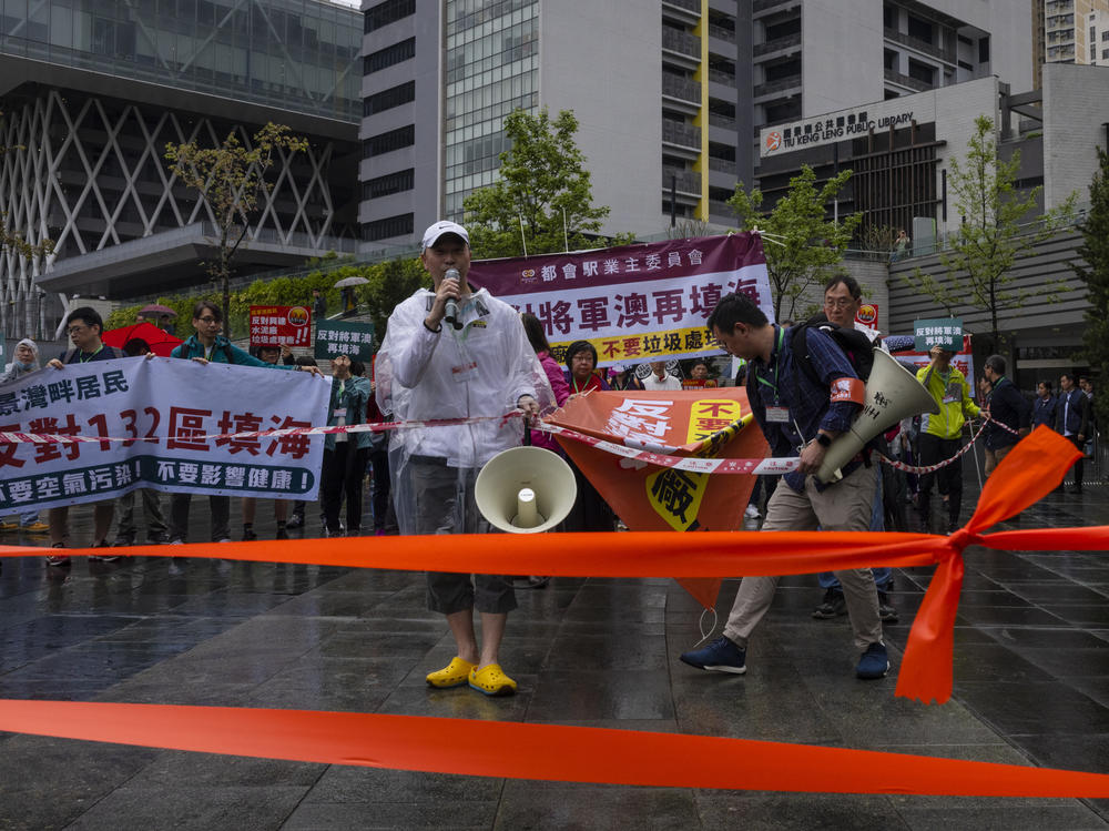Protesters wearing number tags during a rally in Hong Kong, Sunday. Dozens of people on Sunday joined Hong Kong's first authorized demonstration against the government since the lifting of major COVID-19 restrictions under unprecedentedly strict rules, including wearing a numbered badge around their necks.
