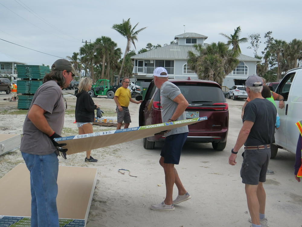 Volunteers load free drywall into trucks and SUVs during a recent giveaway at Beach Baptist Church on Fort Myers Beach. Charlie Doster was among those collecting the maximum 25 sheets. 