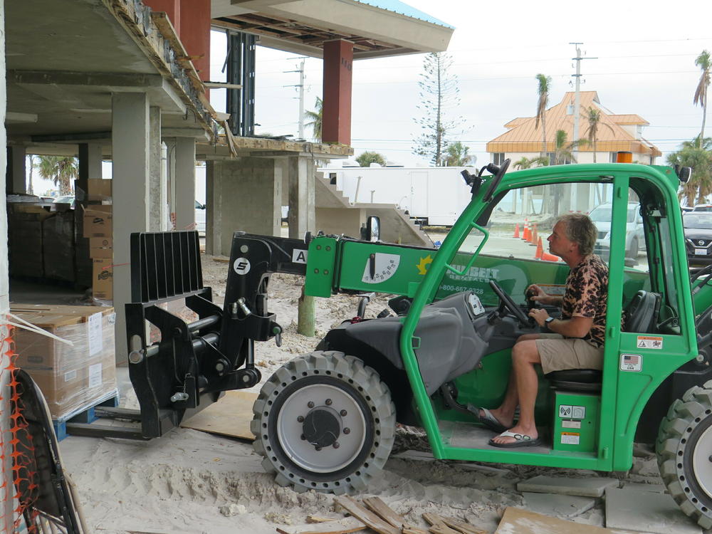 Pastor Shawn Critser of Beach Baptist Church operates a forklift moving supplies into his damaged church. With the help of a developer, he hopes his rebuilt church complex will include workforce housing.
