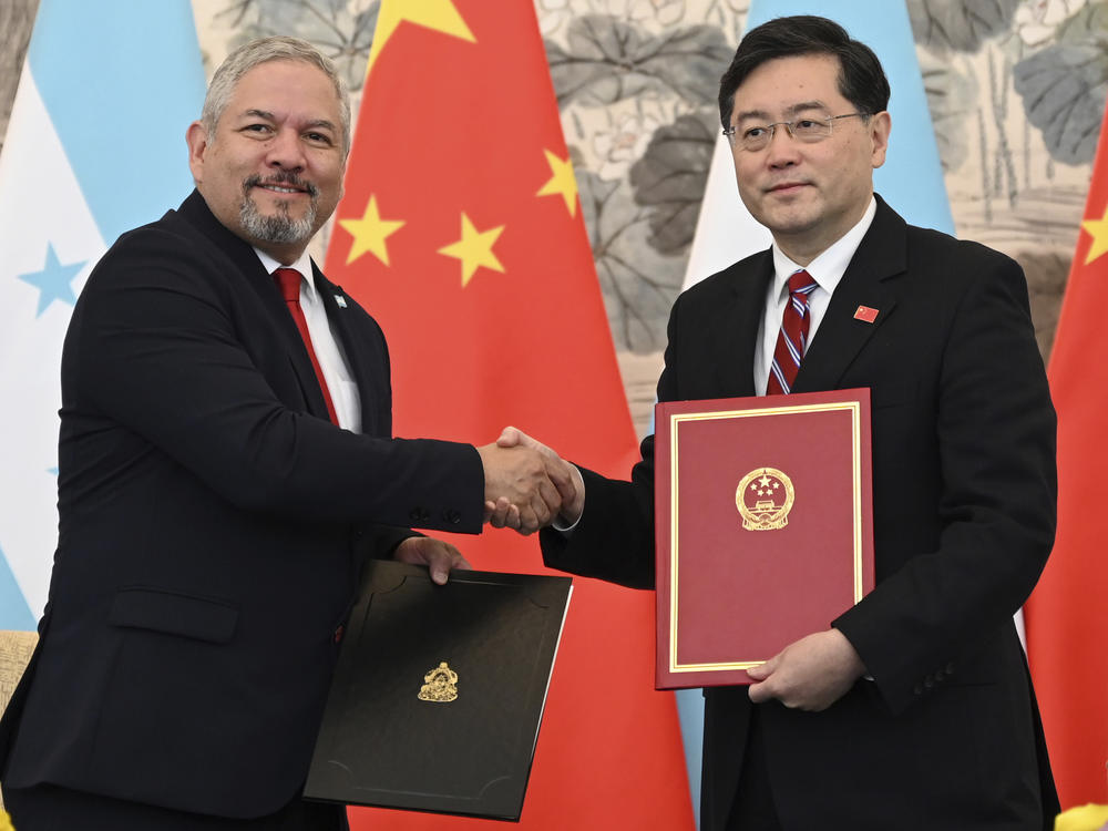Honduras Foreign Minister Eduardo Enrique Reina Garcia, left, and Chinese Foreign Minister Qin Gang shake hands following the establishment of diplomatic relations between the two countries, at a ceremony in the Diaoyutai State Guesthouse in Beijing Sunday, March 26, 2023.