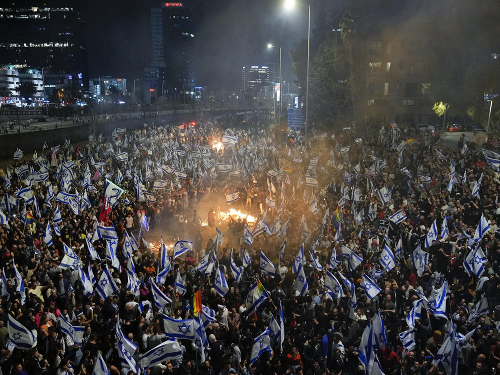 Israelis opposed to Prime Minister Benjamin Netanyahu's judicial overhaul plan set up bonfires and block a highway during a protest moments after the Israeli leader fired his defense minister, in Tel Aviv, Israel, Sunday, March 26, 2023.