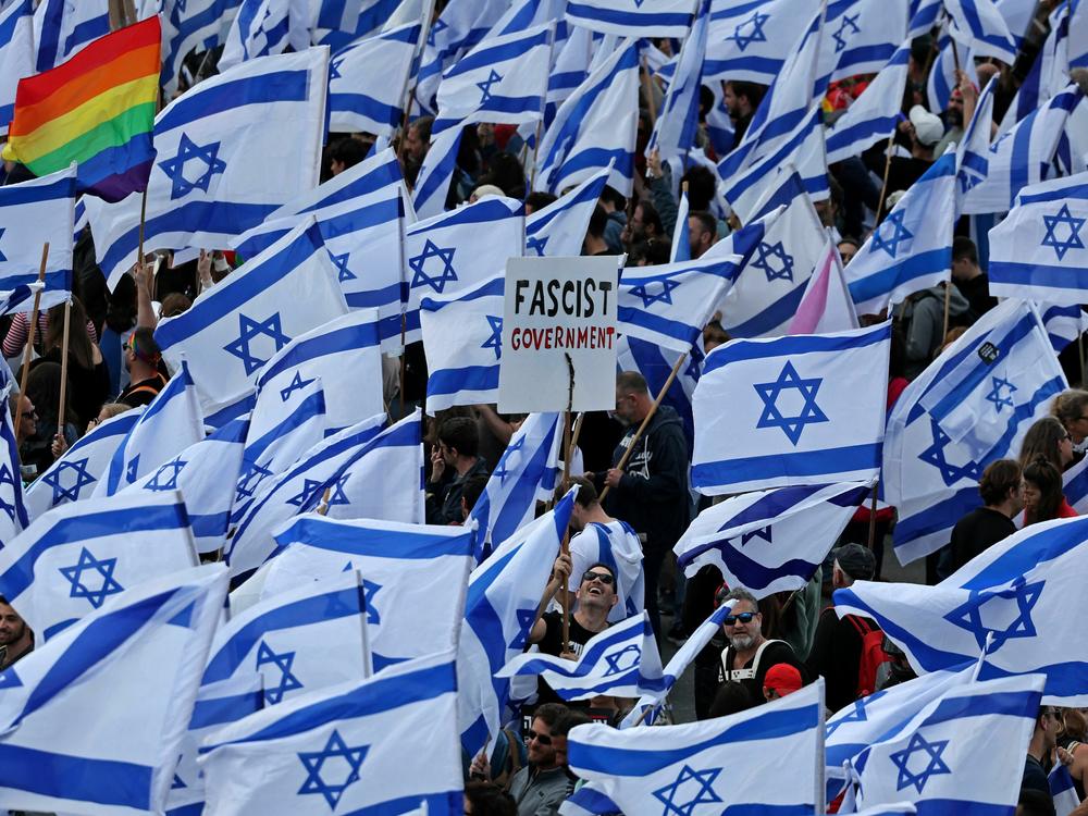 Protesters wave Israeli flags outside parliament in Jerusalem on Monday, part of a massive show of anger over the hard-right government's push to overhaul the justice system.