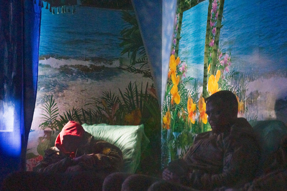 Soldiers relax in the aromatherapy room in dimmed light.