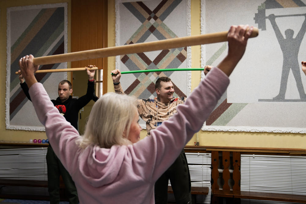 A fitness instructor leads soldiers in a class that helps strengthen their backs.