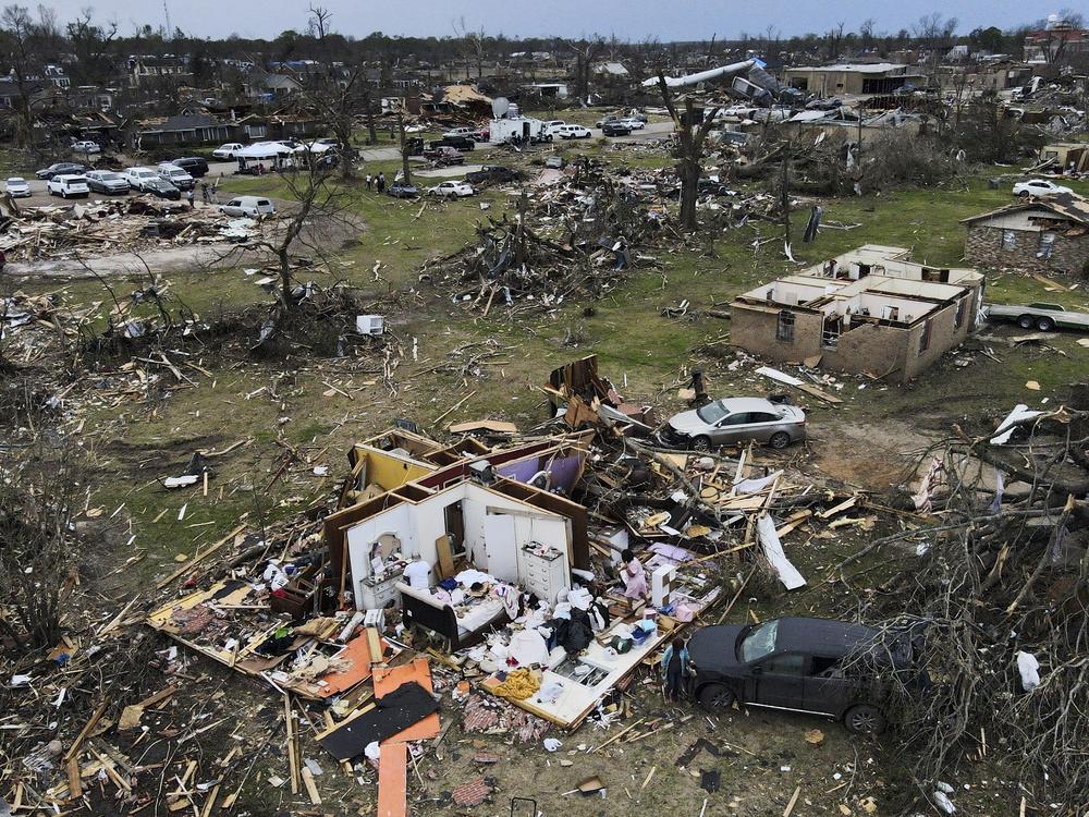 Debris is strewn around tornado damaged homes, Sunday, March 26, 2023, in Rolling Fork, Miss.