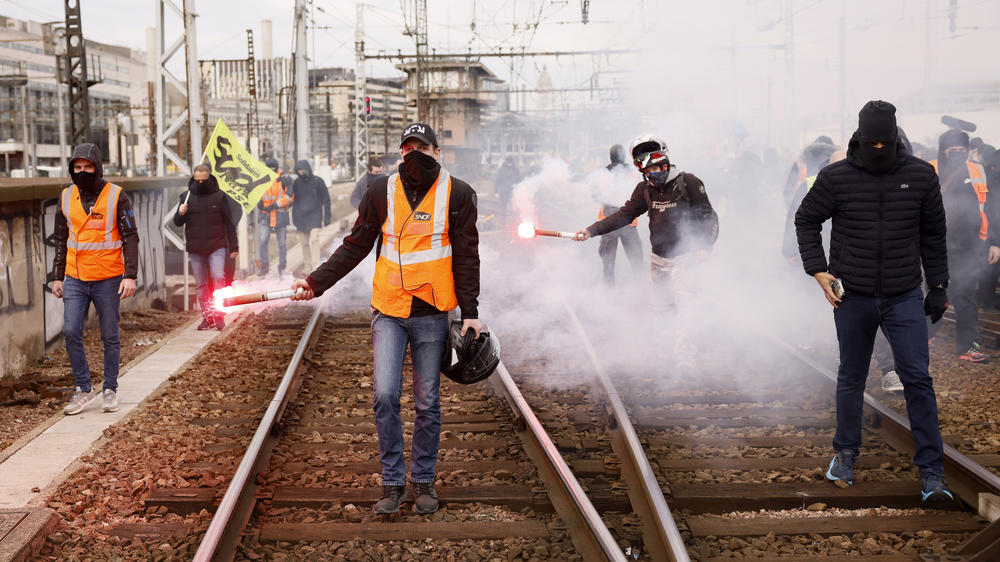 Railway workers demonstrate on the tracks at the Gare de Lyon train station on Tuesday in Paris. A new round of strikes and demonstrations is planned against the unpopular pension reforms that, most notably, push the legal retirement age from 62 to 64.