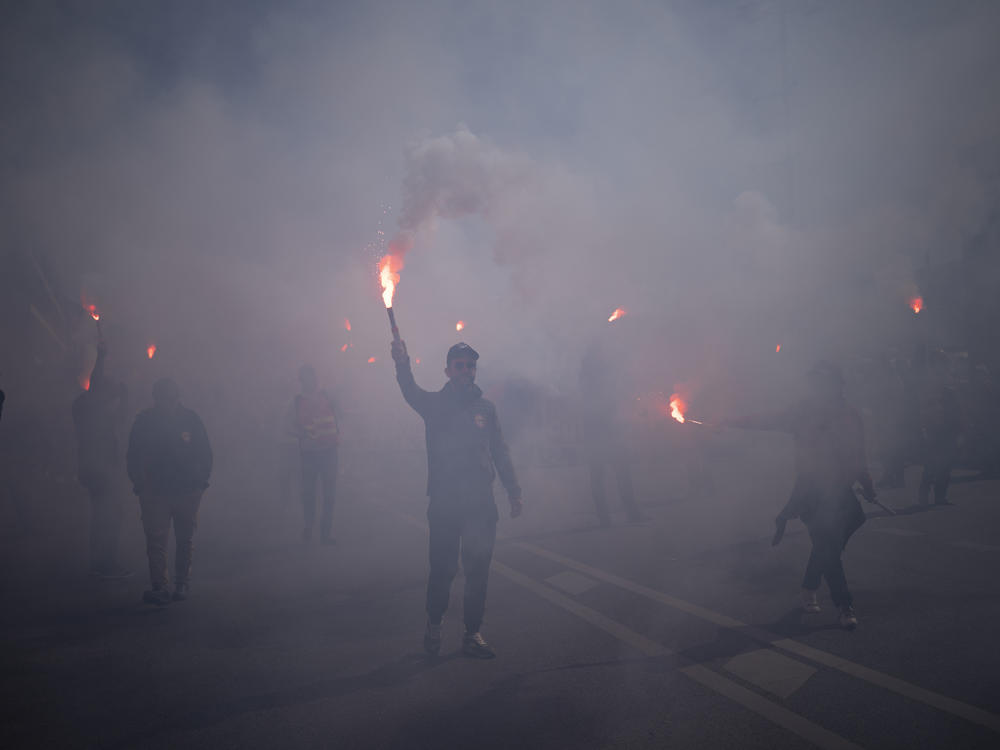 Protesters march with flares during a demonstration in Marseille, southern France, on Tuesday. France's government is unfurling massively ramped-up security measures for a fresh blast of marches and strikes against unpopular pension reforms.