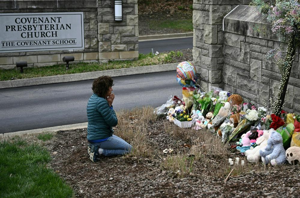 A day after the shooting at the Covenant School, Robin Wolfenden prays at a makeshift memorial for the victims outside the school building.