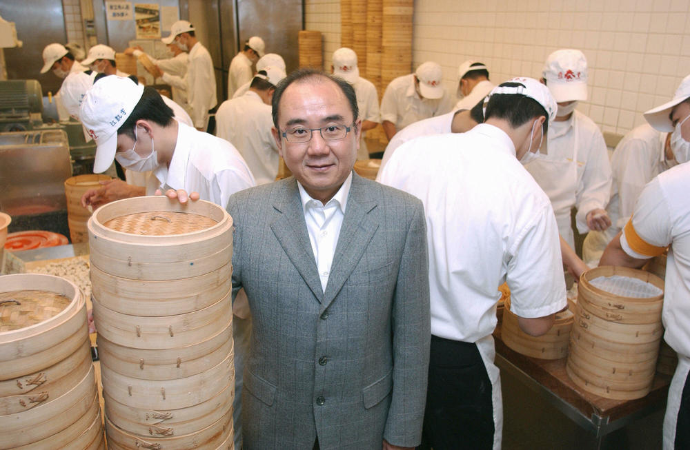 Yang Ji-Hua, who became owner of Taiwan's Din Tai Fung business after his father, stands next to piles of bamboo steamers in Taipei in 2007. Throngs of locals and tourists queue outside Din Tai Fung to sample its specialty steamed dumplings or <em>xiaolongbao.</em>