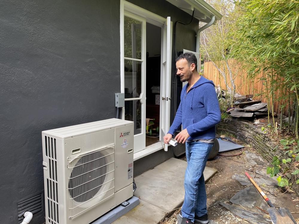 James Tucker with his heat pump that replaced his old gas furnace.
