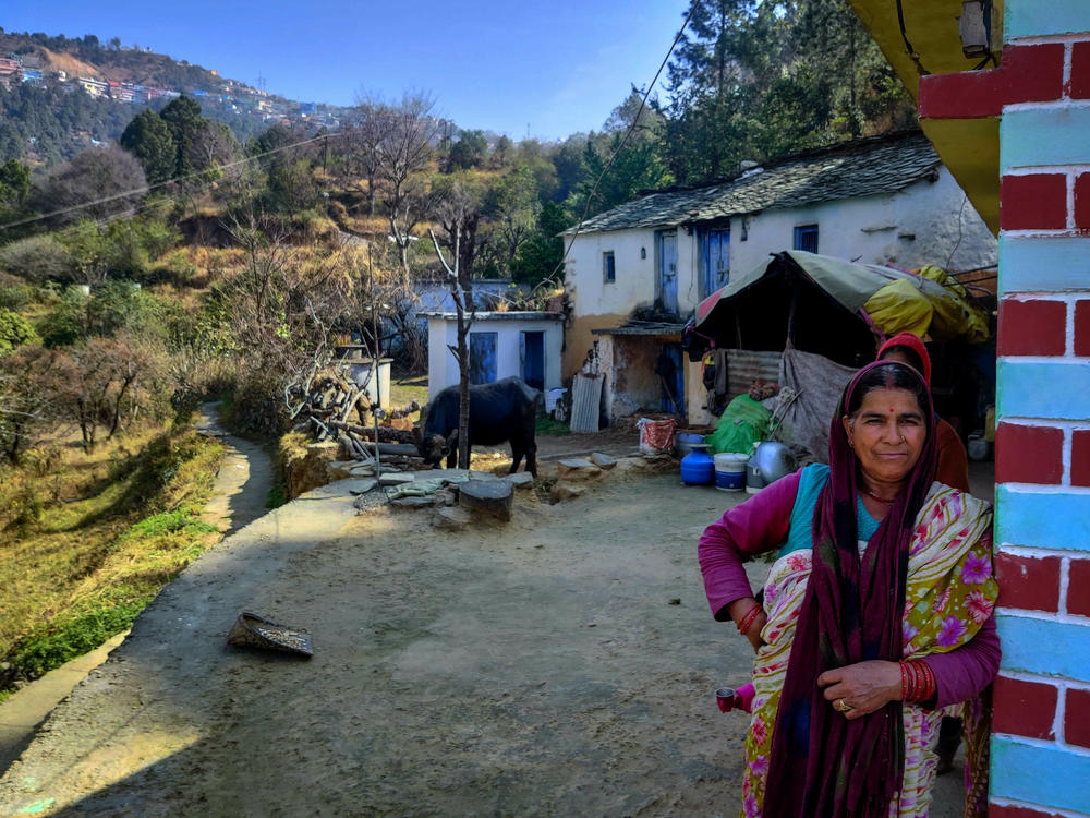 Krishna Lal stands in front of her house. The town of Chamba is on the hill behind her.