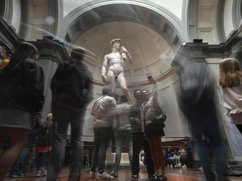 Tourists take photos in front of Michelangelo's David in the Accademia Gallery in Florence, Italy, on Tuesday. The Florence museum and the city's mayor are inviting parents and students from the Florida charter school to visit and see Michelangelo's sculpture in person.