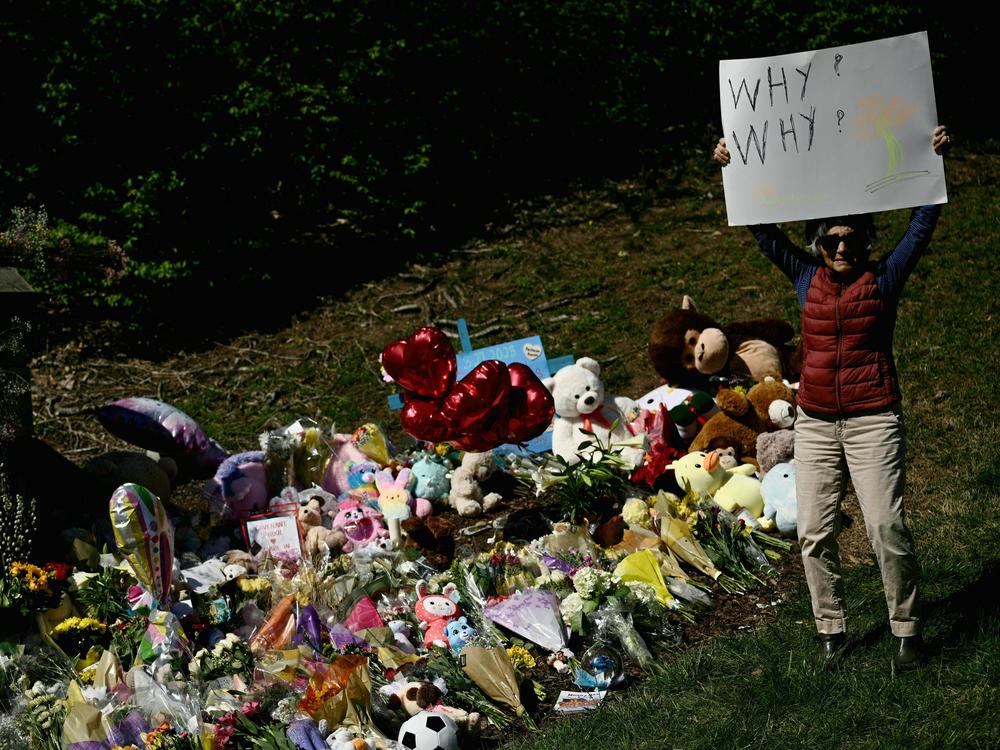 A mourner on Wednesday holds a sign reading 