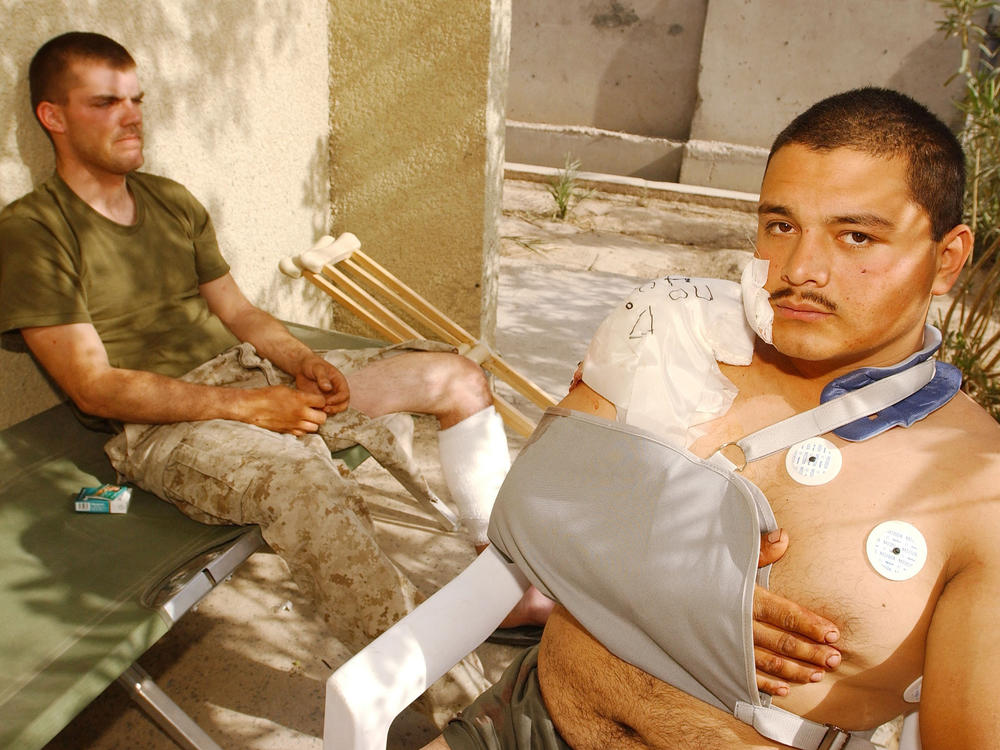 U.S. Marine Corps Lance Cpls. Chris Covington (left) and Carlos Gomez Perez recover from shrapnel and bullet wounds on April 27, 2004, after Iraqi insurgents attacked near Fallujah, Iraq. Just two weeks earlier, Covington and Gomez Perez helped evacuate wounded Marines and soldiers after a deadly explosion rocked a schoolhouse in Fallujah.