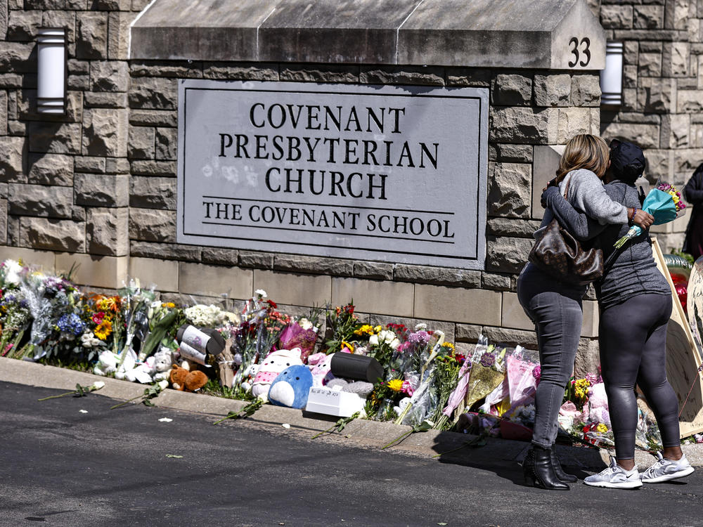 People hug at a memorial at the entrance to the Covenant School on Wednesday in Nashville, Tenn.