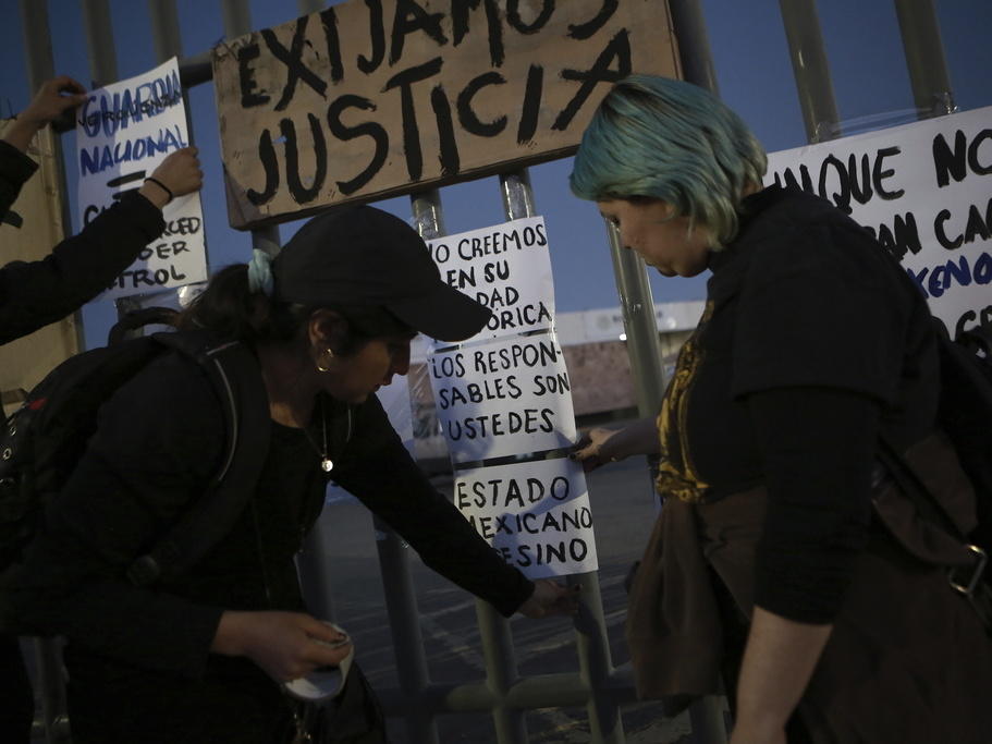 Activists post signs Wednesday as they protest outside a migration detention center in Ciudad Juarez, Mexico, a day after dozens of migrants died as a result of the fire.