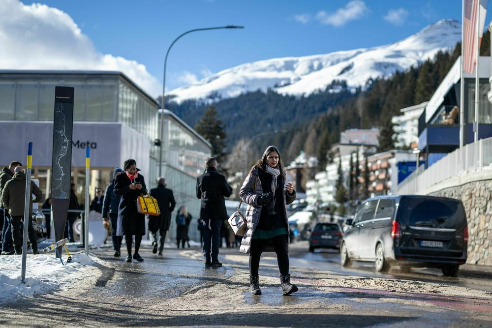 Participants walk in the street of the Alpine resort of Davos during the World Economic Forum annual meeting on Jan. 18. The gathering of the world's elites in Davos has become a focal point for many conspiracy theories.