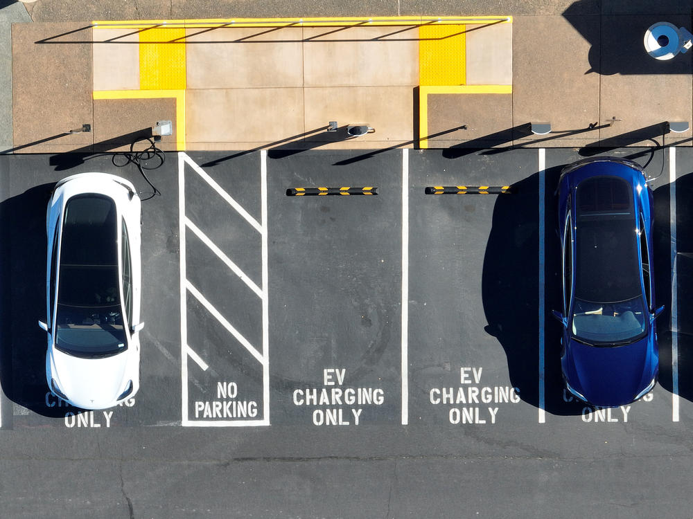 In an aerial view, Tesla cars recharge at a Tesla charger station in Corte Madera, Calif., on Feb. 15, 2023. The Biden administration wants to boost sales of electric cars, but it also wants to incentivize U.S.-based production.