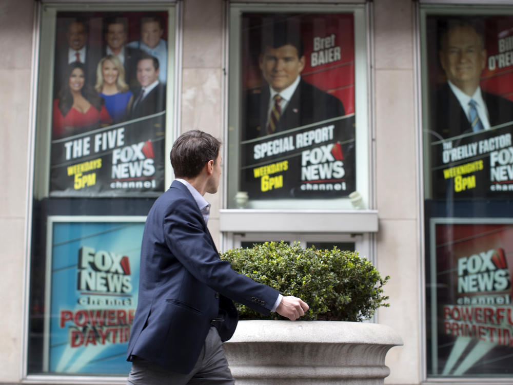 A pedestrian walks past the News Corp. headquarters building in New York displaying posters featuring Fox News Channel personalities on April 19, 2017.