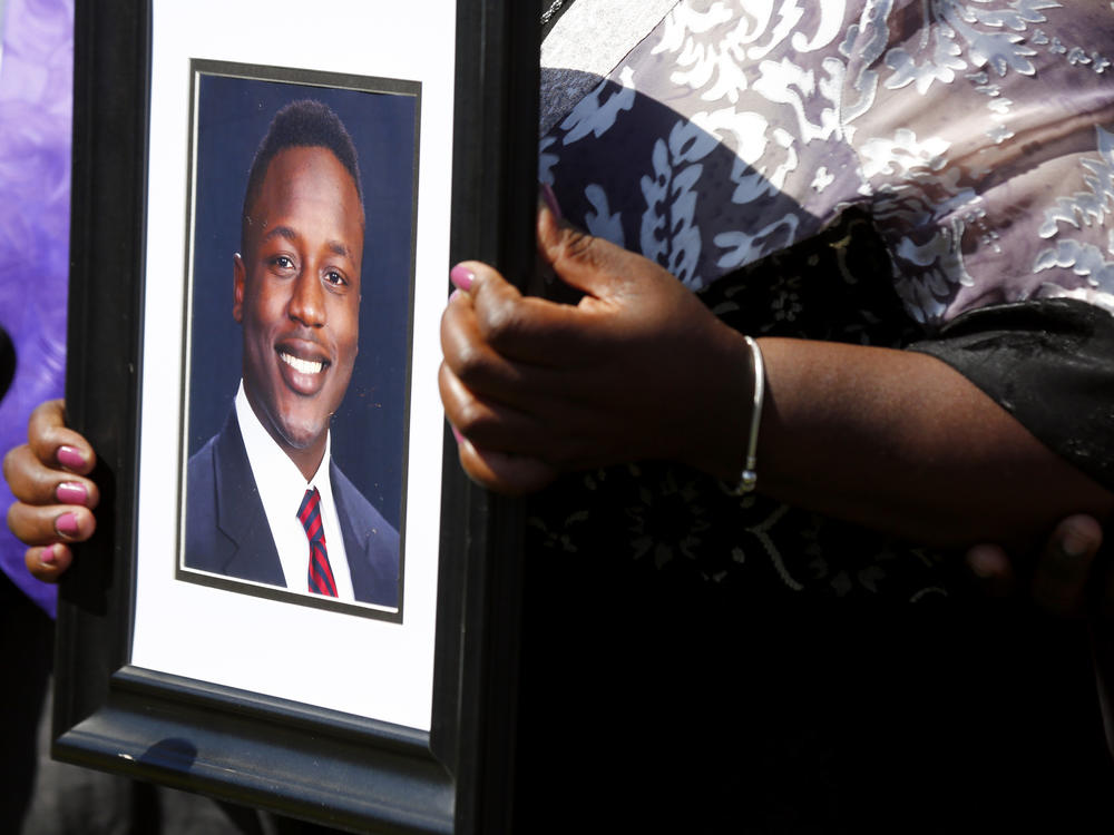 Ouko holds a portrait of her son outside the Dinwiddie Courthouse in Dinwiddie, Va., on March 16.