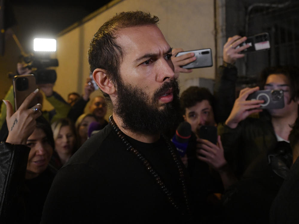 Young fans and media surround Andrew Tate as he leaves a police detention facility in Bucharest, Romania, after his release from prison on Friday.