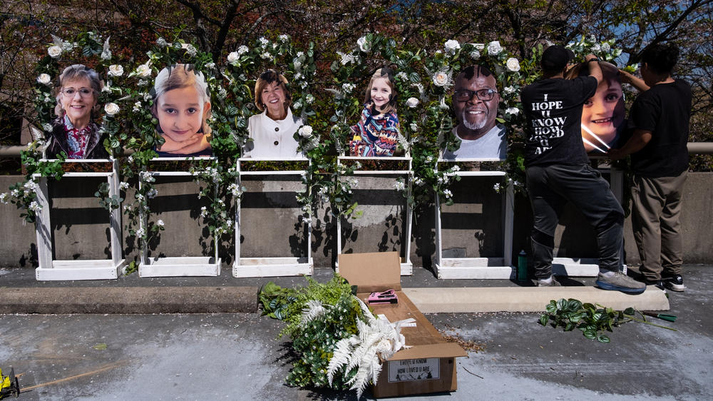 Pictures of the victims killed in a mass shooting on Monday at the Covenant School are fixed to a memorial by Noah Reich (left) and David Maldonado from the nonprofit Classroom of Compassion, near the school on Wednesday in Nashville, Tenn.