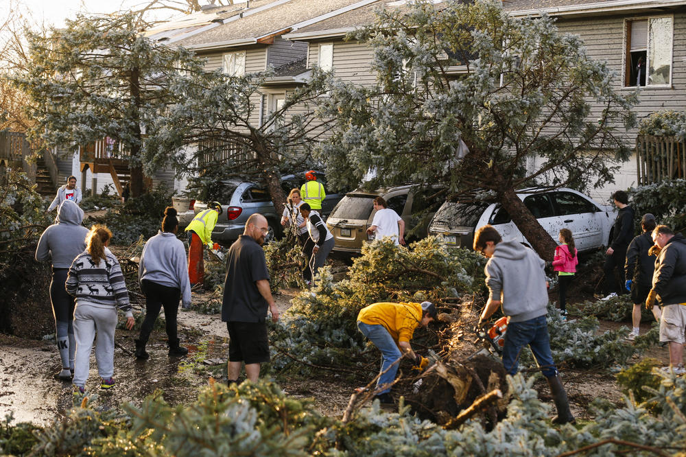 Cleanup begins after a tornado touched down in Coralville, Iowa, on Friday. City crews, residents and neighbors worked to clear debris off the roadway and vehicles.