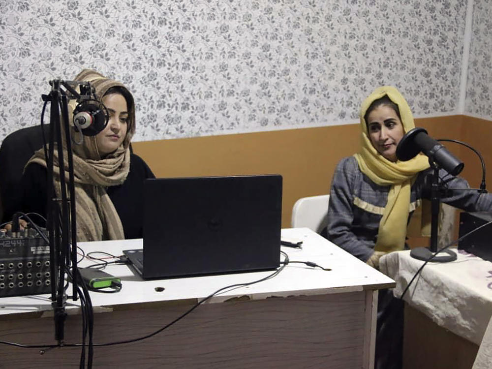 Najia Sorosh, head of Sadai Banowan a women-run radio station, left, speaks into a microphone in the studio in Badakhshan province, Afghanistan, on Jan. 4. A women-run radio station in Afghanistan's northeast has been shut down for playing music during Ramadan, a Taliban official said.