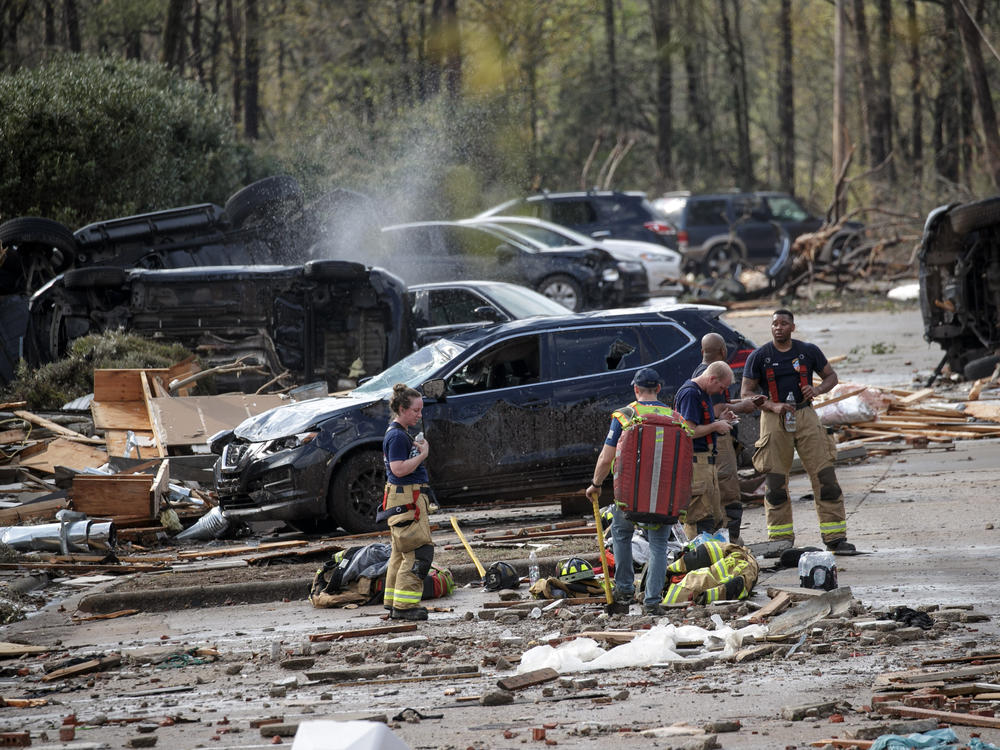 Emergency responders rest after helping residents evacuate an apartment complex Friday in Little Rock.