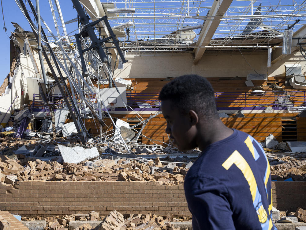 Jeremiah Burrell, 14, walks past the destroyed gym at Crestview Elementary School in Covington, Tenn., on Saturday.