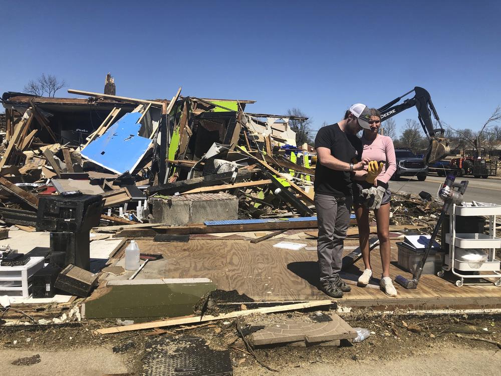 Two people stand in front of a destroyed business in Wynne, Ark., on Saturday.