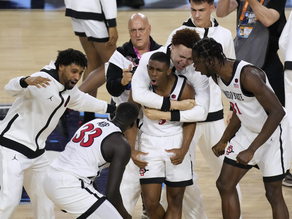 San Diego State guard Lamont Butler, center, celebrates with teammates after he hit the winning basket against Florida Atlantic during the second half of a Final Four game on Saturday.