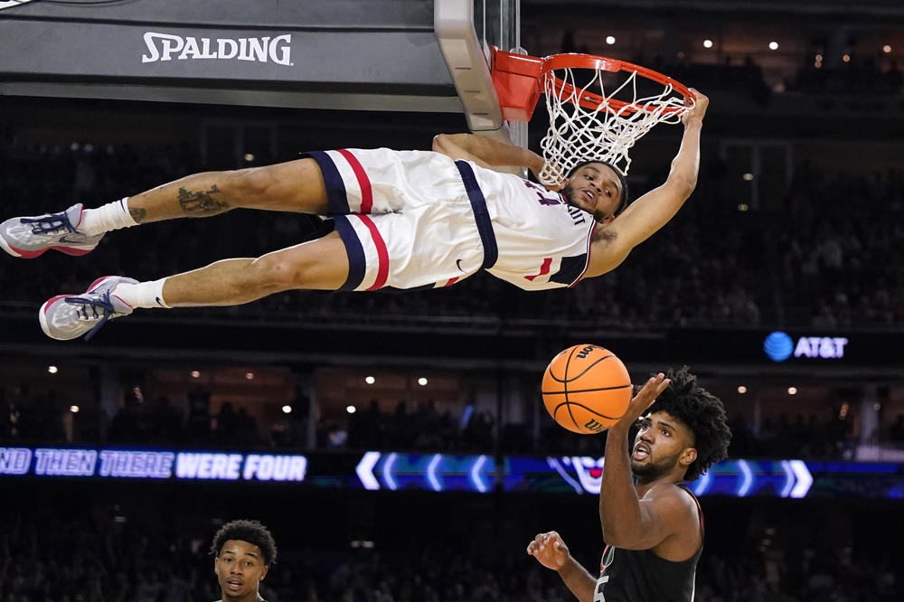 Connecticut guard Andre Jackson Jr. dunks the ball over Miami forward Norchad Omier, right, during the second half of a Final Four college basketball game in the NCAA Tournament on Saturday.