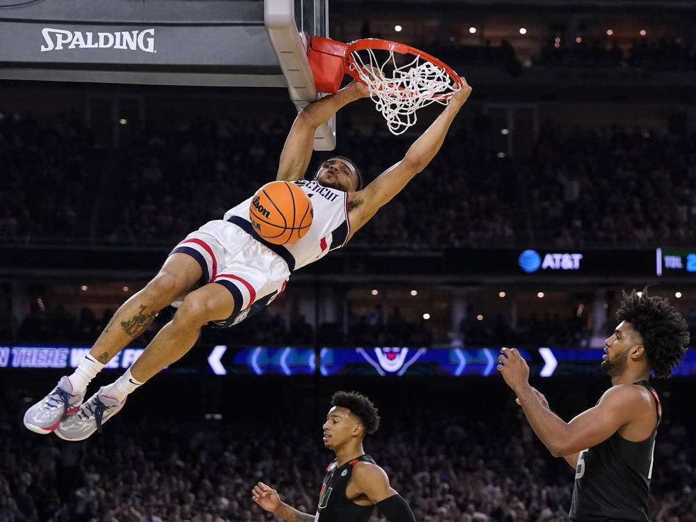 Connecticut guard Andre Jackson Jr. dunks the ball over Miami forward Norchad Omier, right, during the second half of a Final Four college basketball game in the NCAA Tournament on Saturday, April 1, 2023, in Houston.