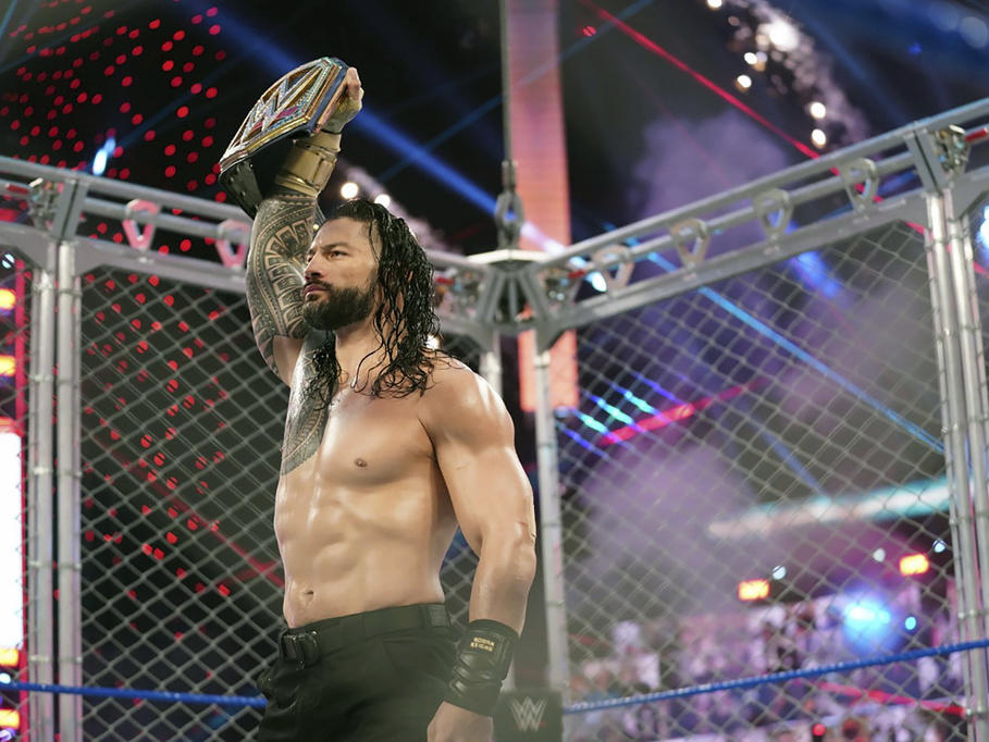 Roman Reigns holds up the WWE Universal Championship belt after defeating Jey Uso during an October 2020 match in Orlando, Fla.