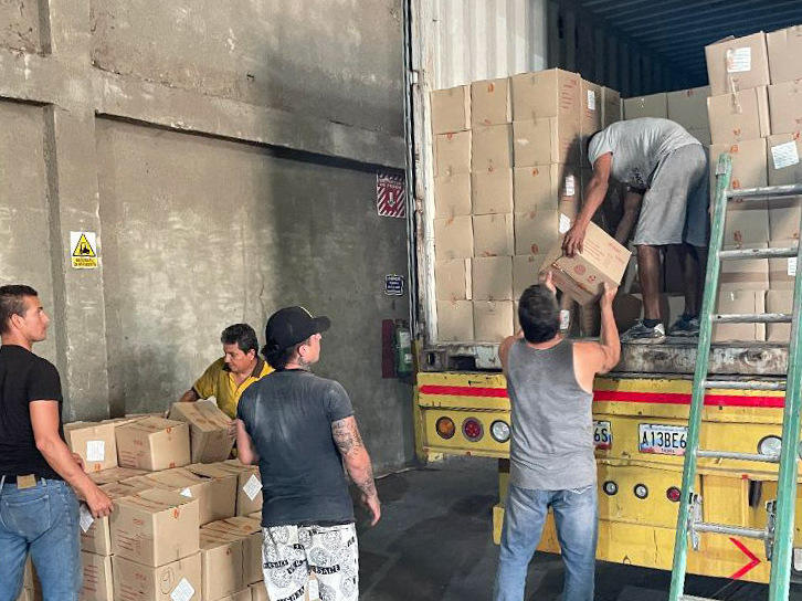 Workers unload boxes of mayonnaise for inspection by customs officials at a warehouse in the Venezuelan border town of San Antonio del Táchira.