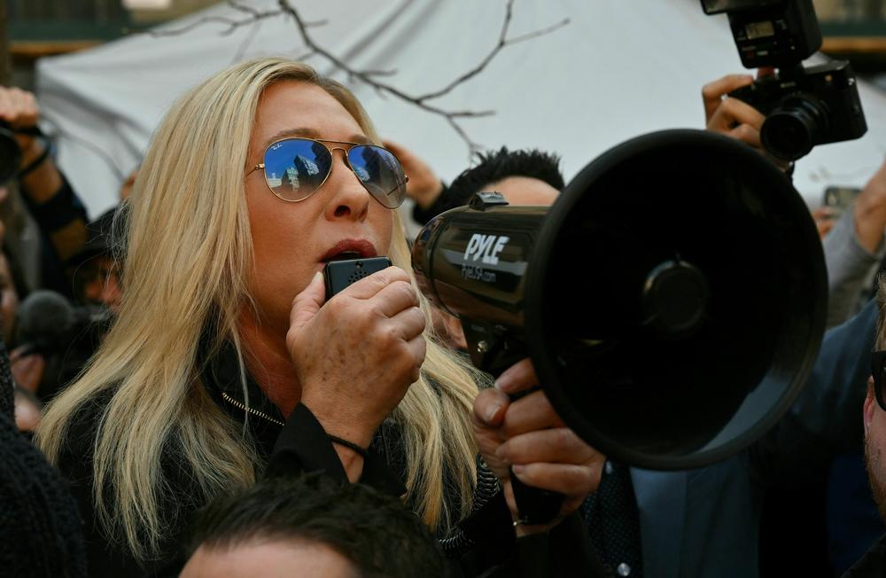 Rep. Marjorie Taylor Greene, R-Ga., talks to supporters of former President Donald Trump outside the District Attorney's Office in New York.