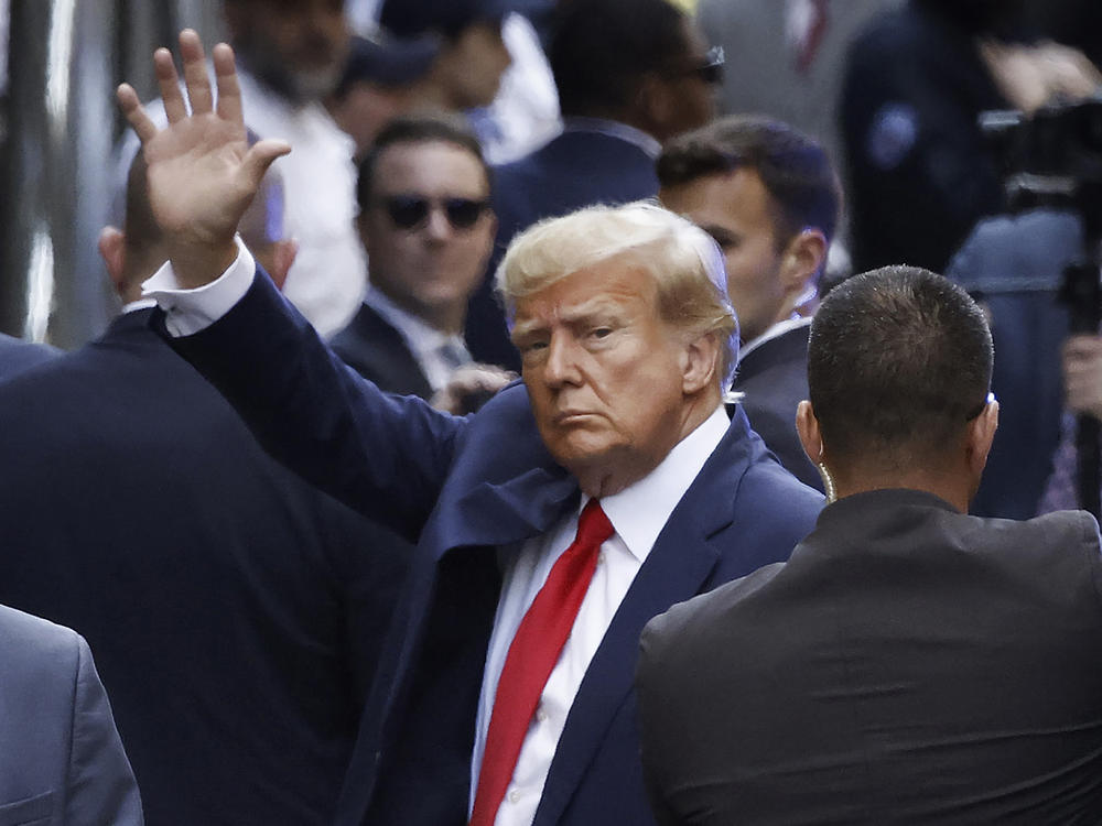 Former President Donald Trump waves as he arrives at criminal court in Manhattan for his arraignment hearing on Tuesday.