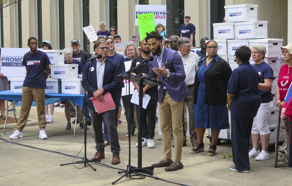 Supporters of the Promote the Vote measure, which did get on the Michigan ballot last year, gather in Lansing on July 11, 2022, in front of boxes containing a portion of their collected petition signatures.