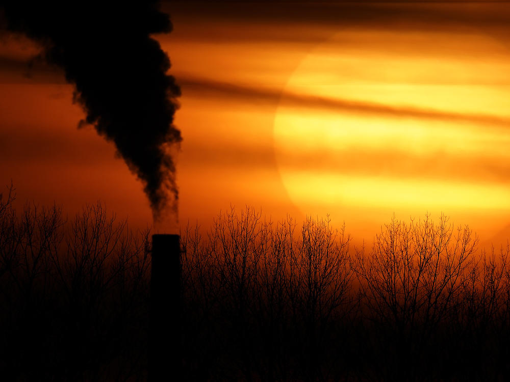 Emissions from a coal-fired power plant are silhouetted against the setting sun in Kansas City, Mo., on Feb. 1, 2021. The Environmental Protection Agency is tightening rules that limit emissions of mercury and other harmful pollutants from coal-fired power plants, updating standards imposed more than a decade ago.
