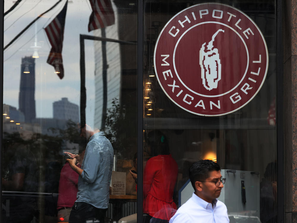 People walk past a Chipotle store in New York City. The fast casual restaurant known for its burritos and bowls is suing Sweetgreen over alleged trademark infringement.
