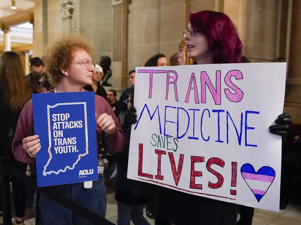 Protesters stand outside of the Senate chamber at the Indiana Statehouse on Feb. 22, 2023, in Indianapolis. Republican Governors in Indiana and Idaho have signed into law bills banning gender-affirming care for minors early April 2023, making those states the latest to prohibit transgender health care this year.