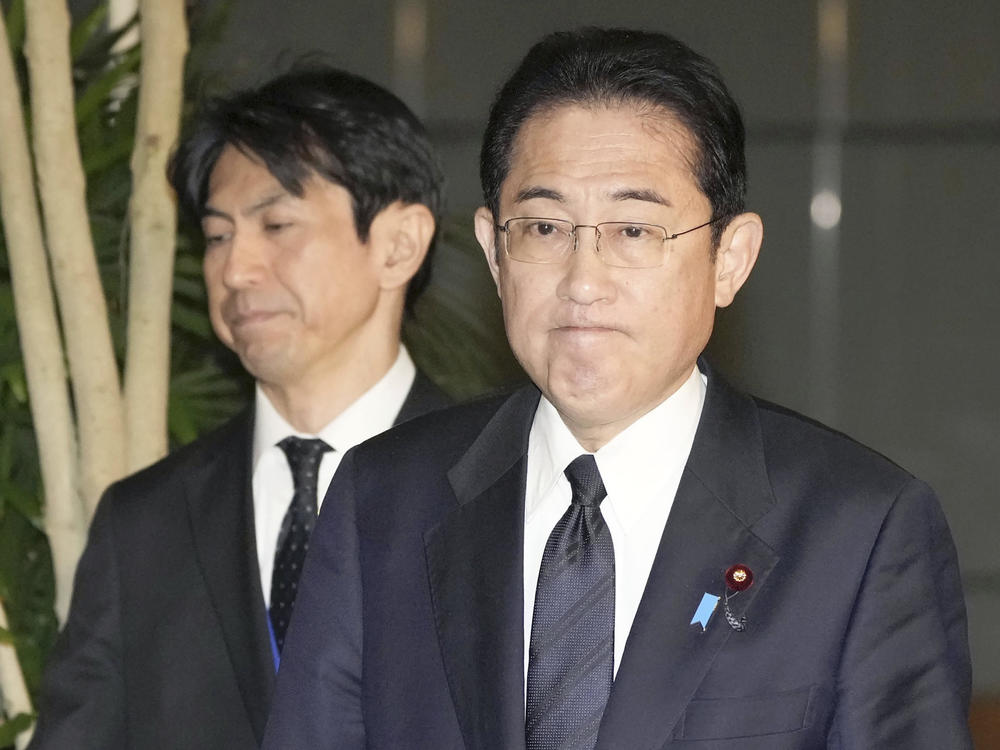 Japan's Prime Minister Fumio Kishida (right) meets with reporters in Tokyo after an army helicopter went missing on Thursday.