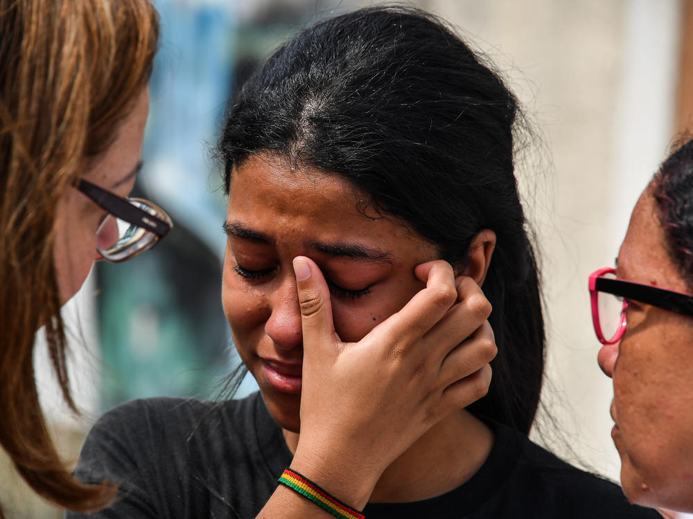 A student cries after the 2019 attack on a public school in the state of Sao Paulo, Brazil. The attack, by two former students, resulted in 10 deaths, including the attackers, who turned their weapons on themselves. It was one of the deadliest school attacks in the country's history.