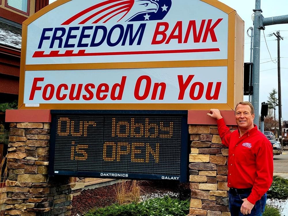 Don Bennett, the founder and CEO of Freedom Bank in Columbia Falls, Mont., stands in front of his lender. Bennett founded the bank in his basement and has expanded it over the years.
