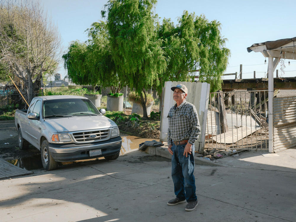 Antonio Hueso, 72, stands in the driveway of his home in Pajaro, California after floodwaters in mid March flooded the first floor of his home and submerged his truck. He's considering repairing his home of 48 years and selling.