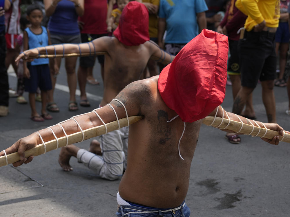 Hooded Filipino penitents carry pointed bamboo sticks as part of Maundy Thursday rituals to atone for sins or fulfill vows for an answered prayer on April 6, 2023 at Mandaluyong city, Philippines.