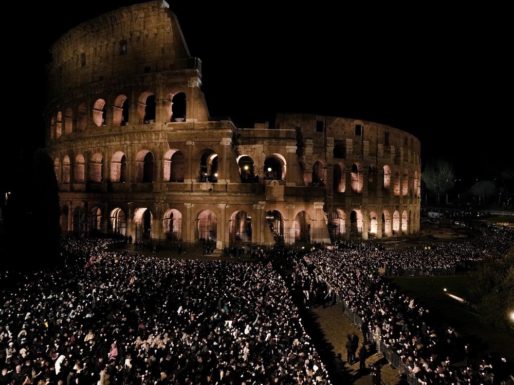 People hold candles during a Via Crucis (Way of the Cross) torchlight procession on Good Friday in Rome on Friday, April 7, 2023.