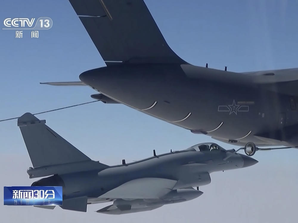 In this image taken from video footage run Saturday by China's CCTV, a Chinese fighter jet performs an mid-air refueling maneuver at an unspecified location.