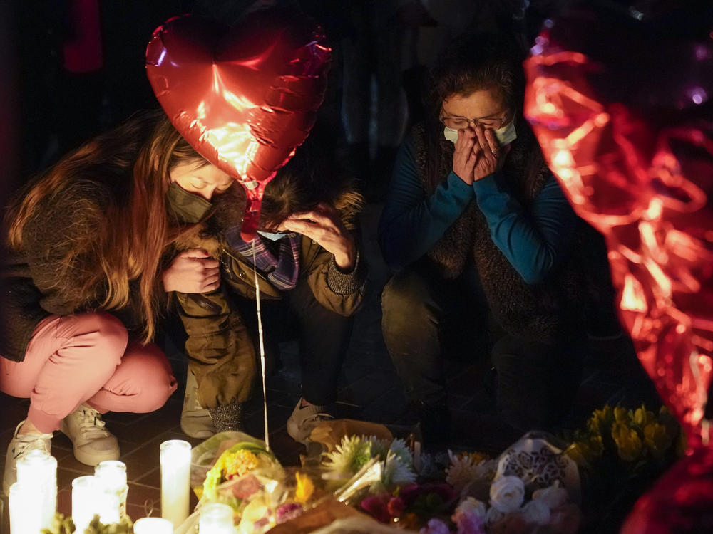 Women pause at a memorial at a vigil honoring the victims of a shooting at the Star Ballroom Dance Studio on Monday, Jan. 23, 2023, in Monterey Park, Calif.